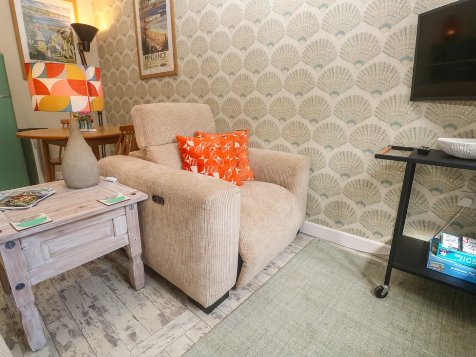 A living room with an armchair and coffee table at The Stable in Rosudgeon