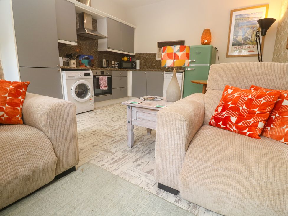 A kitchen with appliances and seating area at The Stable in Rosudgeon