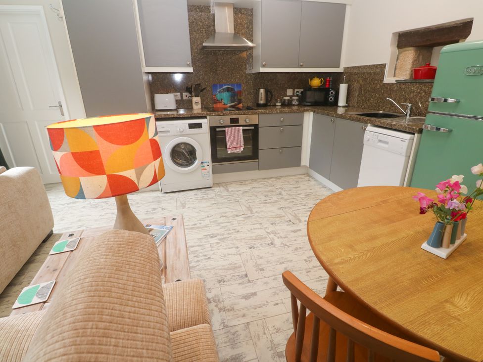 A kitchen with appliances and a dining area at The Stable in Rosudgeon