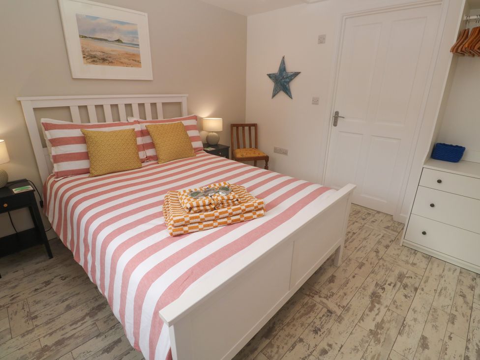 A bedroom with a bed, lamps and furniture at The Stable in Rosudgeon