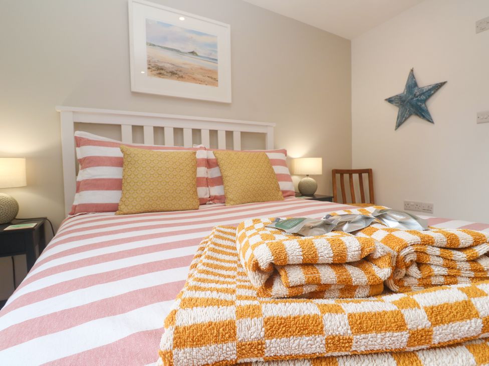 A bedroom with a bed and towels arranged at The Stable in Rosudgeon
