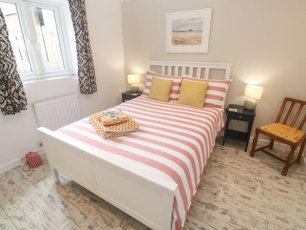 A bedroom with a bed and bedside table at The Stable in Rosudgeon
