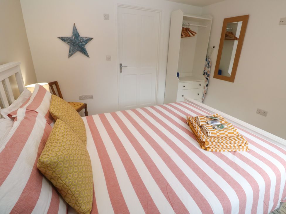A bedroom with a bed and wardrobe at The Stable in Rosudgeon