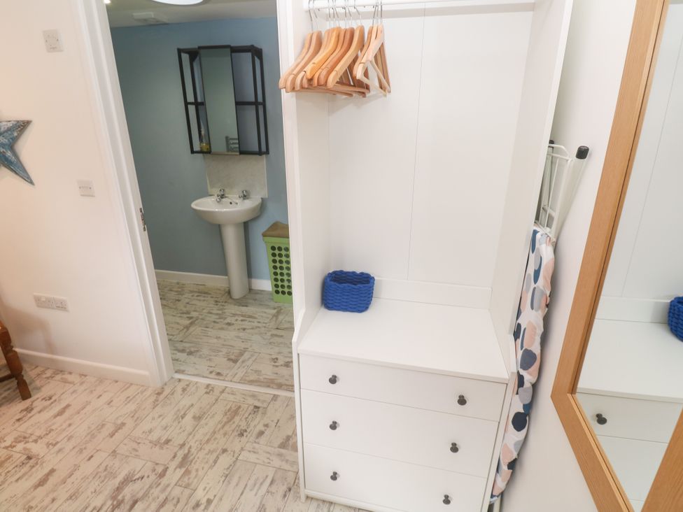 A bathroom with drawers, a mirror, and a sink at The Stable in Rosudgeon