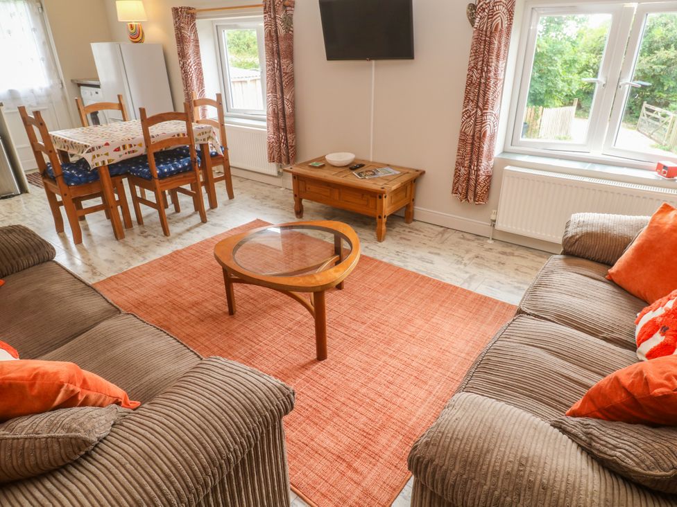 A living room with a dining table and sofa at Sea View Loft in Rosudgeon