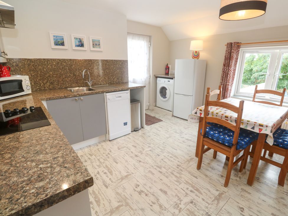 A kitchen with appliances and dining area at Sea View Loft in Rosudgeon