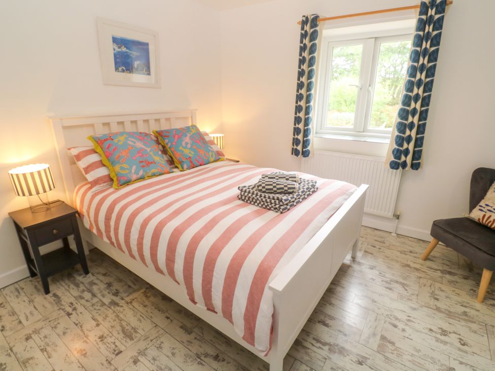 A bedroom with a bed and two lamps at Sea View Loft in Rosudgeon