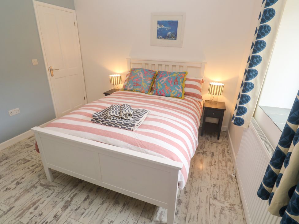A bedroom with a bed and bedside table at Sea View Loft in Rosudgeon