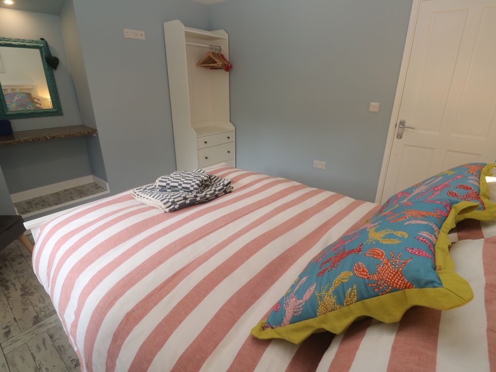 A bedroom with a bed and wardrobe at Sea View Loft in Rosudgeon