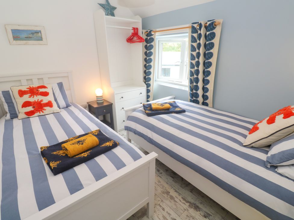 A bedroom with two beds and a wardrobe at Sea View Loft in Rosudgeon