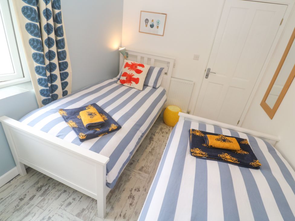 A bedroom with two beds and a mirror at Sea View Loft in Rosudgeon