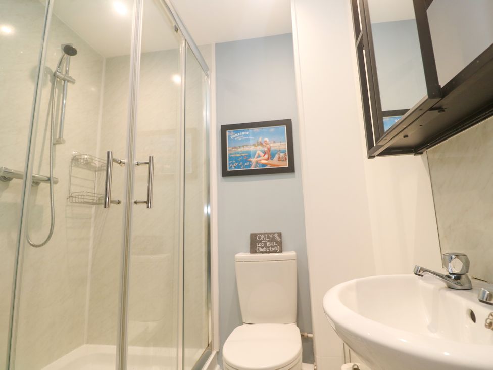 A bathroom with a shower, toilet, and sink at Sea View Loft in Rosudgeon