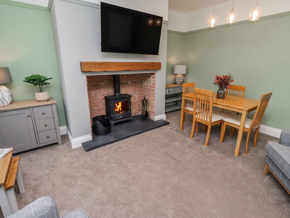 A living room with a fireplace and dining table at 3 Lisburn Street Alnwick