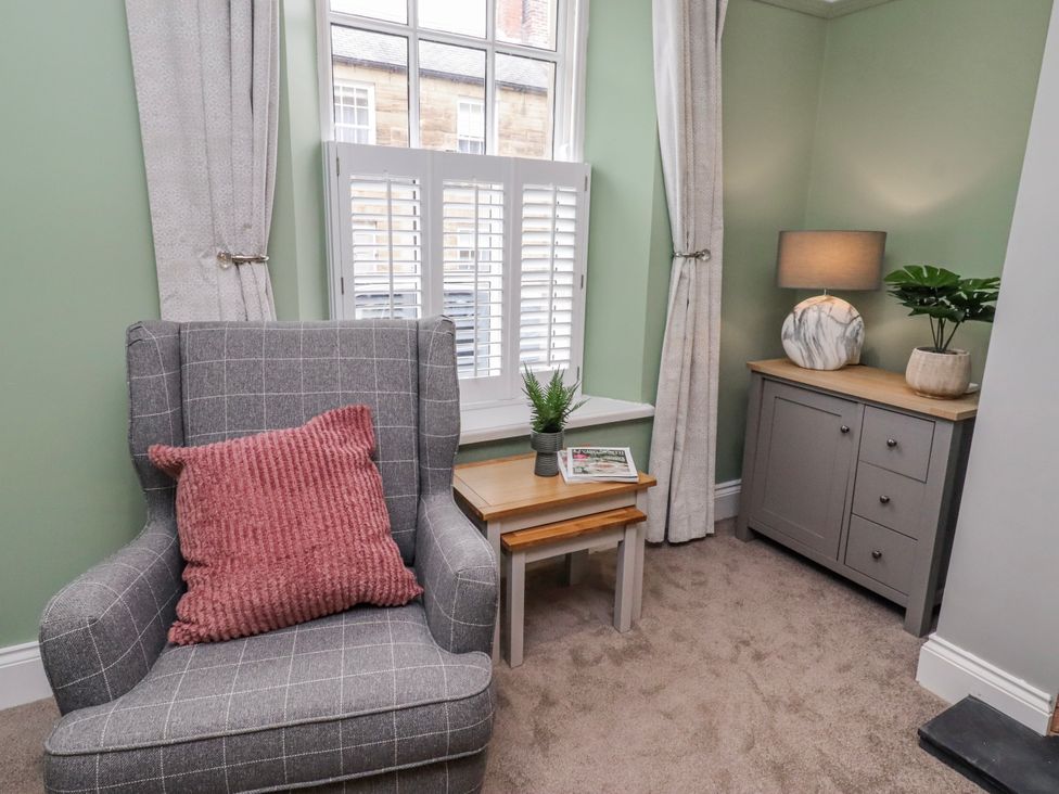 A sitting room with an armchair and a side table at 3 Lisburn Street Alnwick