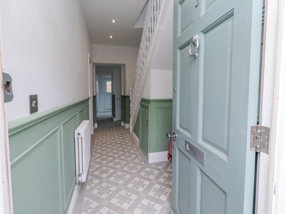 A hallway with a door and stairs at 3 Lisburn Street Alnwick