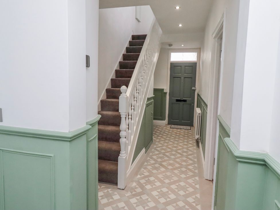 A hallway with a staircase and front door at 3 Lisburn Street in Alnwick