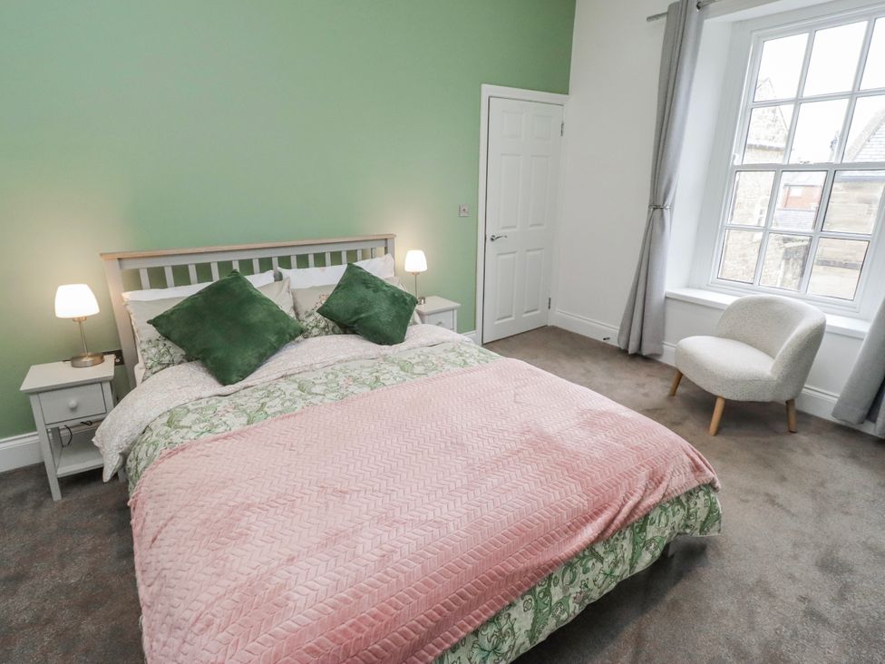 A bedroom with a bed and nightstands at 3 Lisburn Street Alnwick