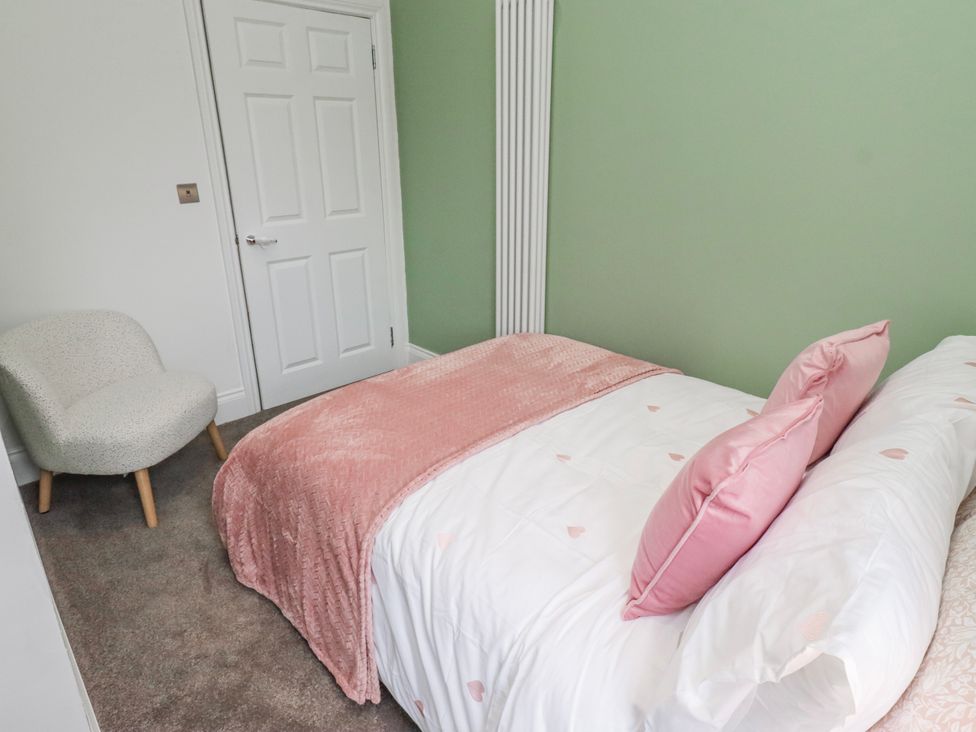 A bedroom with a bed and chair at 3 Lisburn Street in Alnwick