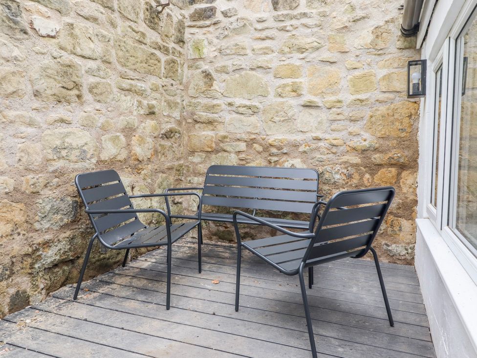 A seating area with metal furniture against a stone wall at 3 Lisburn Street Alnwick