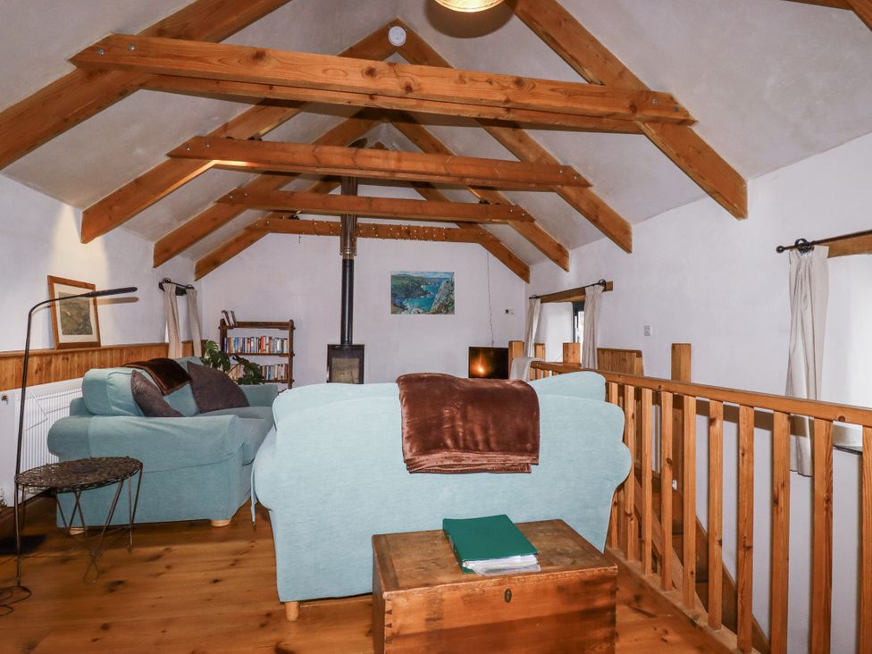 A living room with sofa and wooden beams at Coombe Barn in Cusgarne near St Day