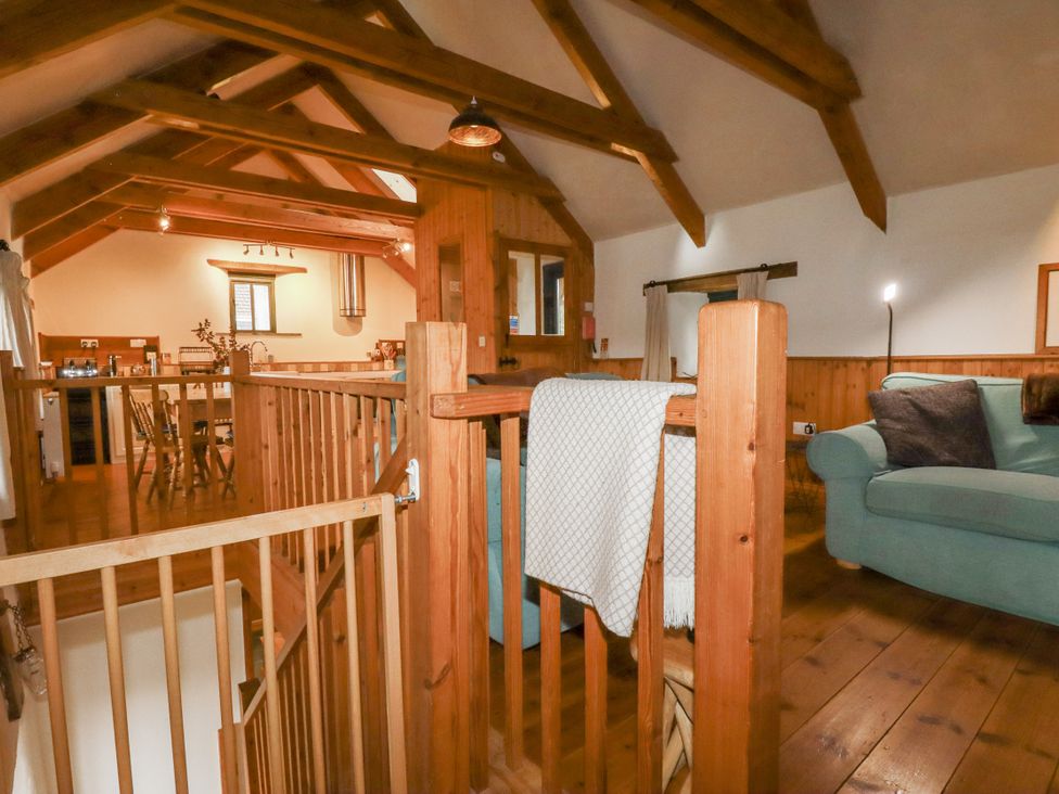 A living room with a sofa and dining table at Coombe Barn Cusgarne near St Day