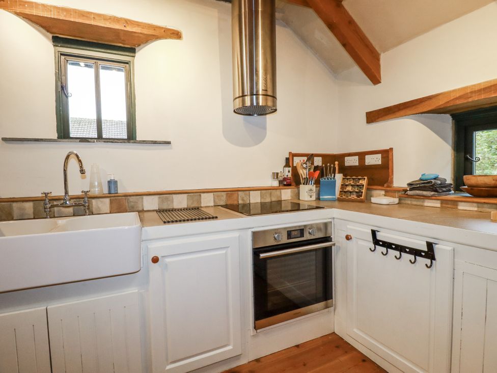 A kitchen with a sink and oven at Coombe Barn Cusgarne near St Day