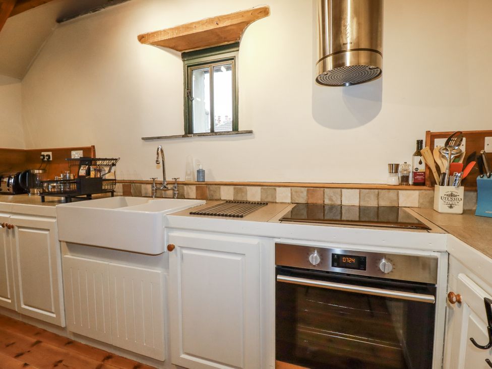 A kitchen with a sink and stove at Coombe Barn Cusgarne near St Day