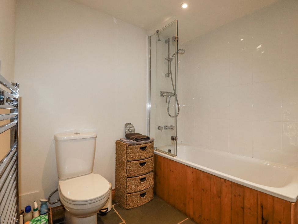 A bathroom with a toilet and a bathtub at Coombe Barn in Cusgarne near St Day