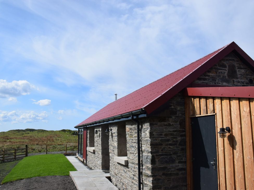 A building exterior with a red roof and stone walls at The Old House, Balure Lismore