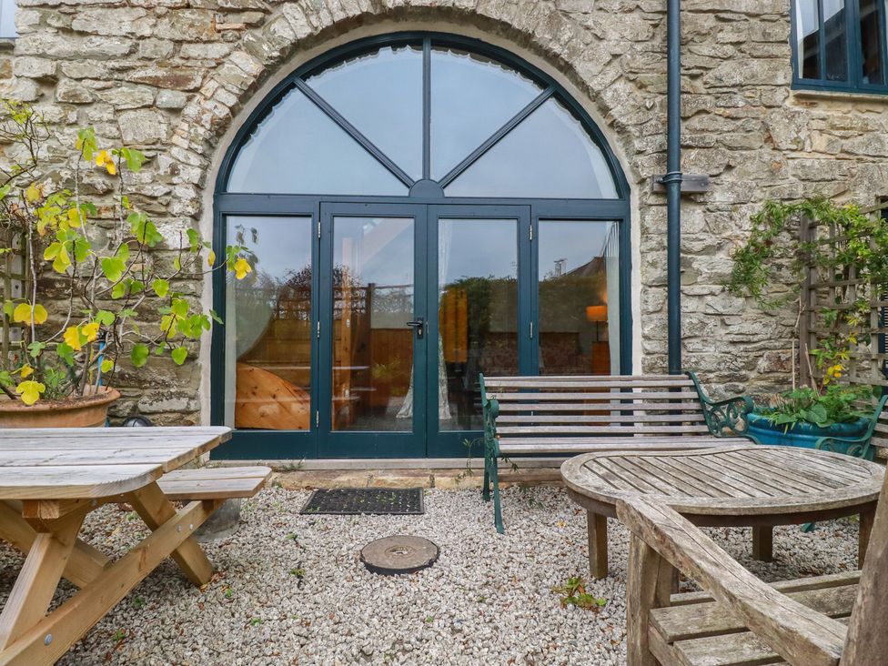 An outdoor area with double doors and seating at Stribleys Barn Cusgarne near St Day