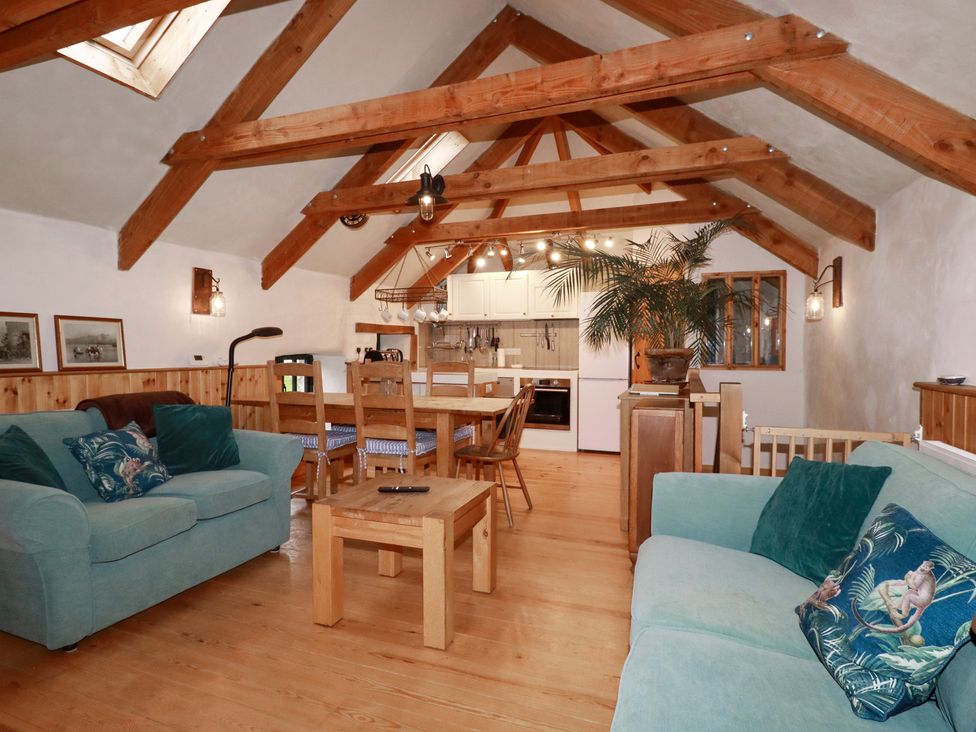 A living room with a sofa and dining table at Stribleys Barn in Cusgarne near St Day