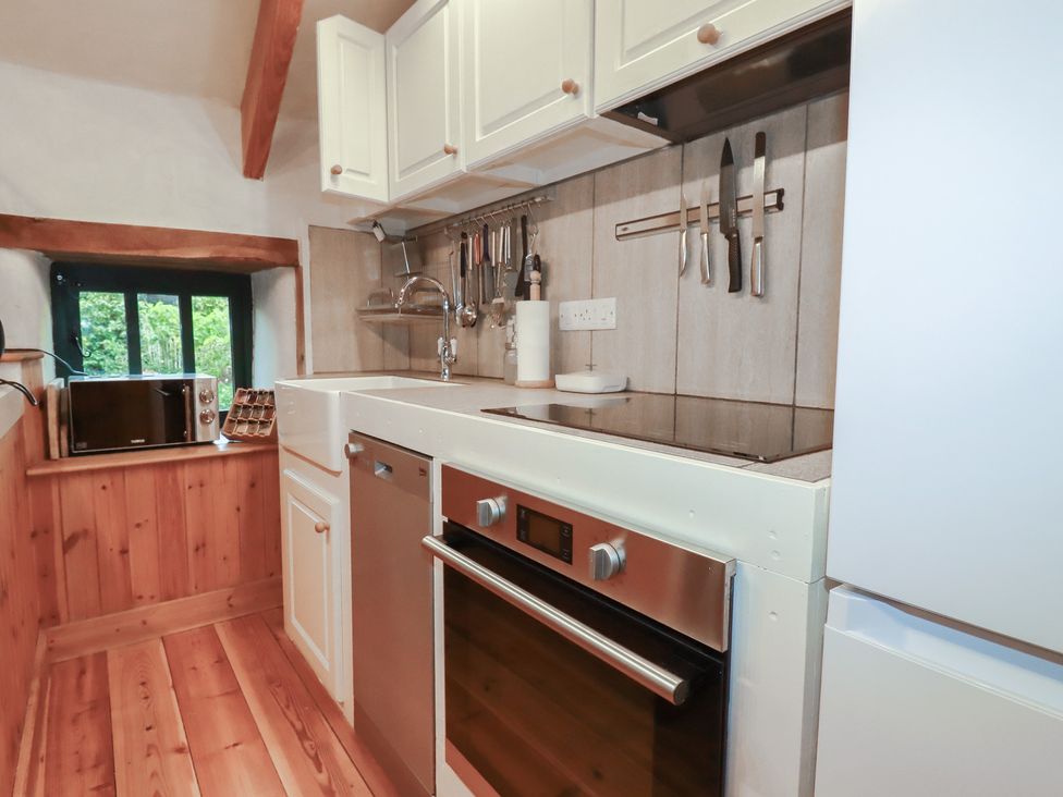 A kitchen with cabinets, a sink, stove, oven, and a microwave at Stribleys Barn in Cusgarne near St Day