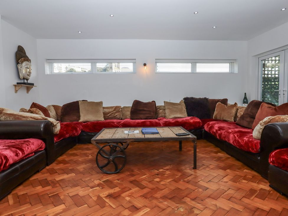 A living room with a large sectional sofa and coffee table at Delmonte Lodge in Torquay