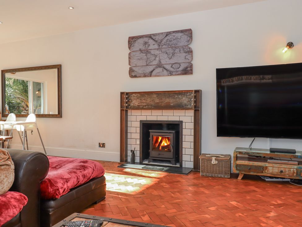 A living room with a fireplace and a television at Delmonte Lodge in Torquay
