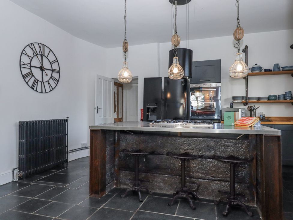 A kitchen with a counter and stools at Delmonte Lodge in Torquay