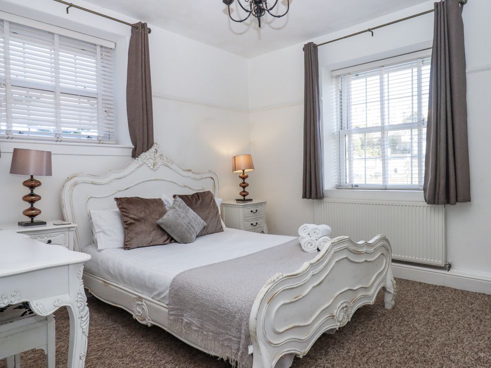 A bedroom with a bed and bedside lamps at Delmonte Lodge in Torquay