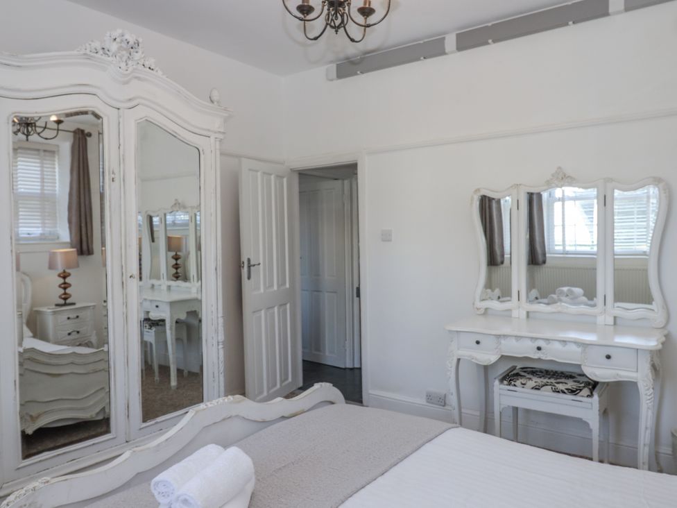 A bedroom with a mirror and dressing table at Delmonte Lodge in Torquay
