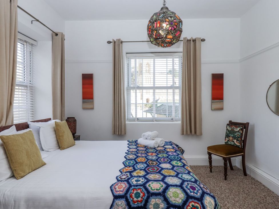 A bedroom with a bed and chair at Delmonte Lodge in Torquay
