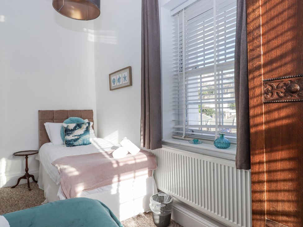 A bedroom with a bed and bedside table at Delmonte Lodge in Torquay