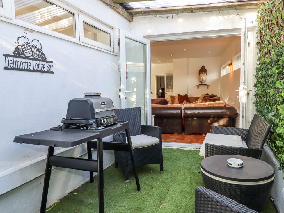 An outdoor area with a grill and seating at Delmonte Lodge in Torquay