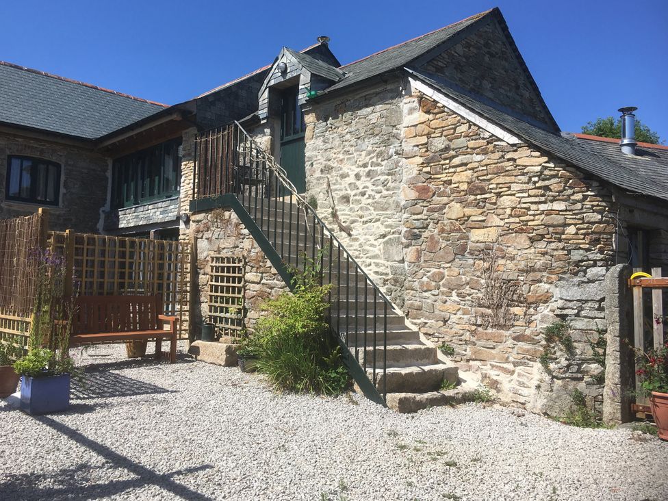 An outdoor view of stairs and a garden bench at Pit Paddy Barn in Cusgarne near St Day