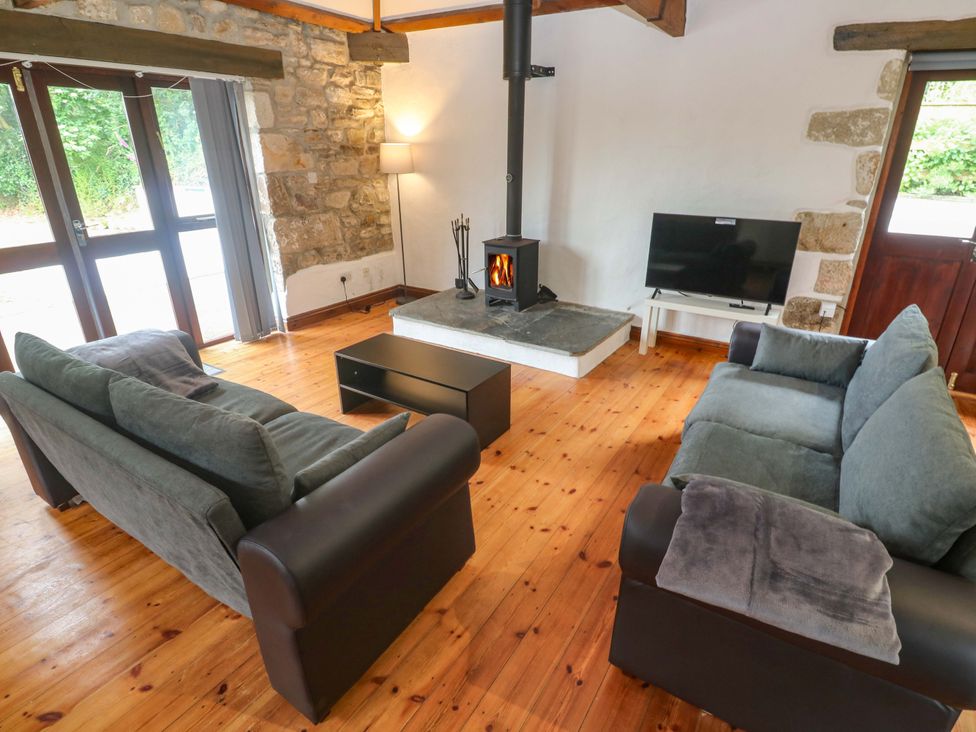 A living room with sofas and a fireplace at The Shippen in Rosudgeon
