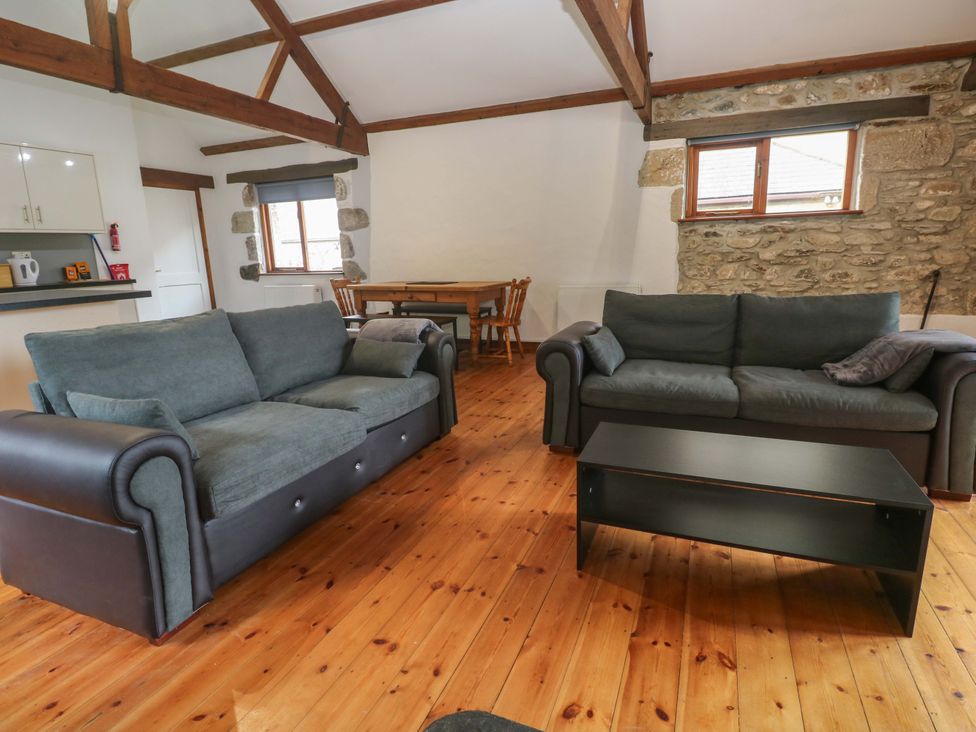 A living room with sofas and a dining area at The Shippen in Rosudgeon