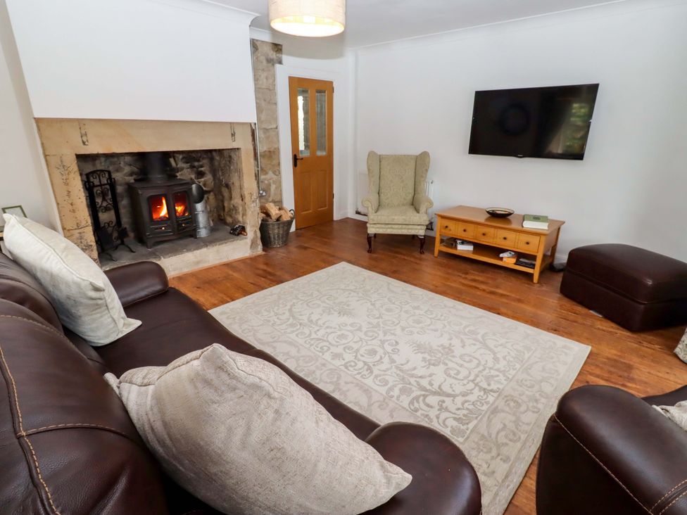 A living room with a fireplace and sofa at The Lodge in Powburn