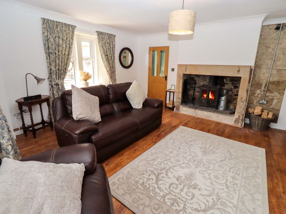 A living room with a fireplace and sofa at The Lodge Powburn
