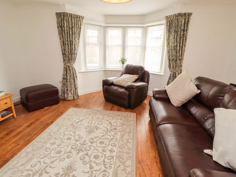 A living room with a sofa and armchair at The Lodge in Powburn