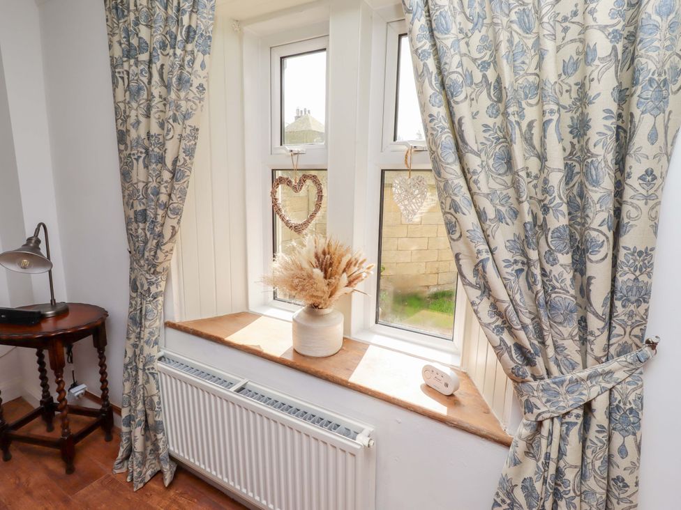 A living room with a window and decorative items at The Lodge in Powburn