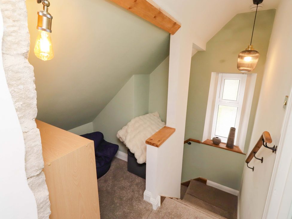 A staircase with a handrail and light fixture at The Lodge in Powburn