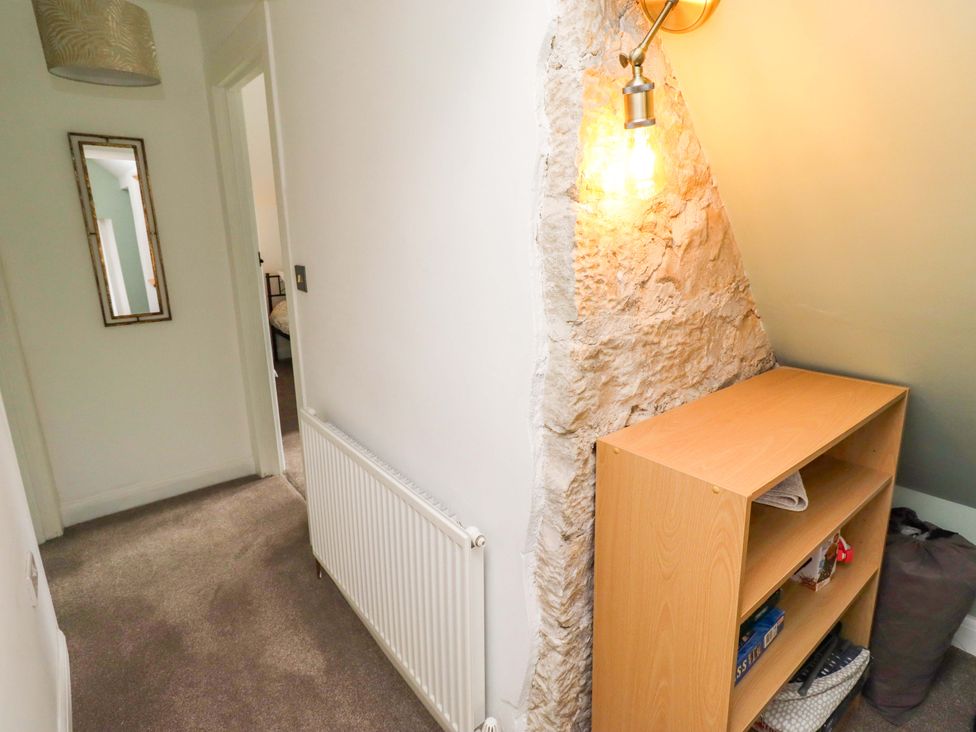 A hallway with a mirror and shelf at The Lodge in Powburn