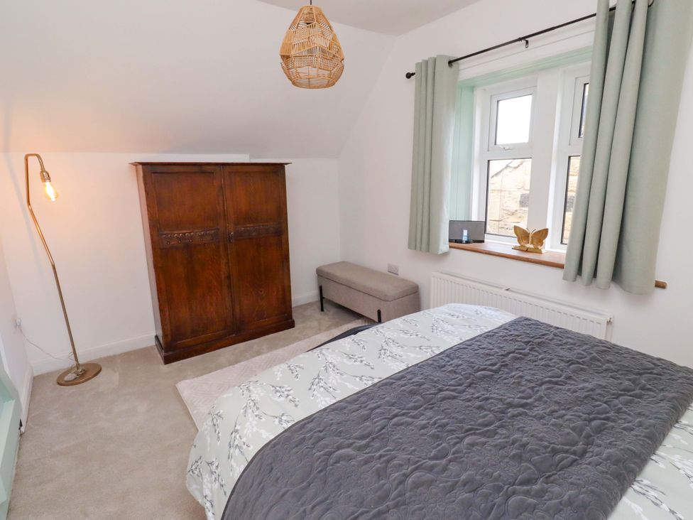 A bedroom with a bed and wardrobe at The Lodge in Powburn